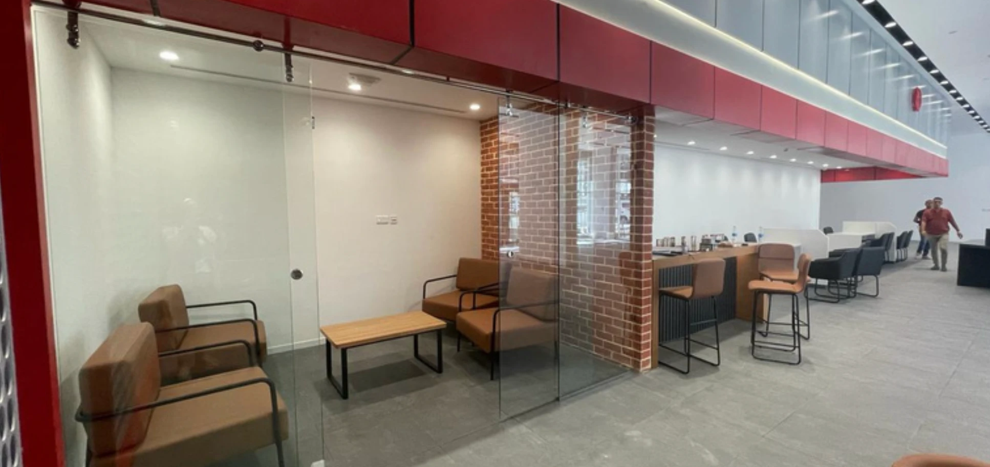 Reception lounge with an exposed brick accent wall and leather seating